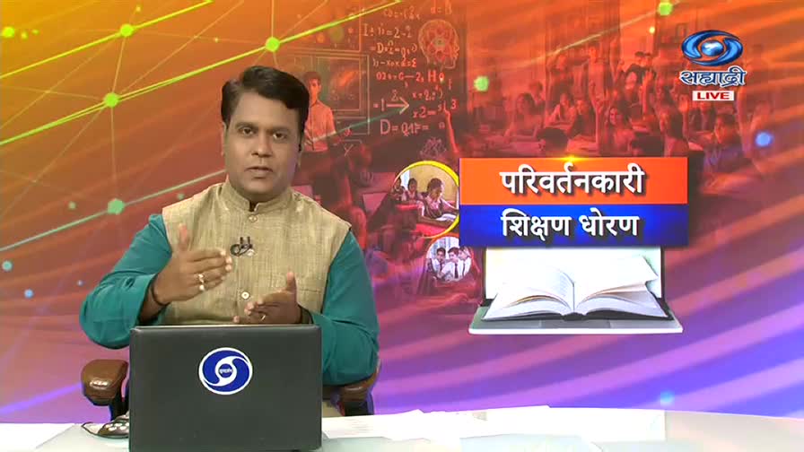 The man in the green and gold vest gestures with both hands, speaking directly to the camera. Behind him, the DD Sahyadri logo and a graphic about education policy are displayed.
