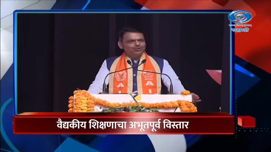 A man in an orange sash stands at a podium, speaking into a microphone. The DD Sahyadri logo appears in the upper right corner.