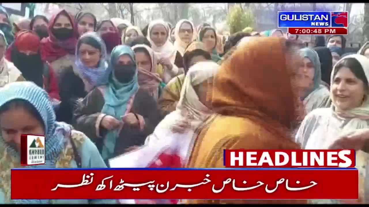 A crowd of women, many in colorful hijabs, are gathered.  A Gulistan News broadcast is playing in the background.