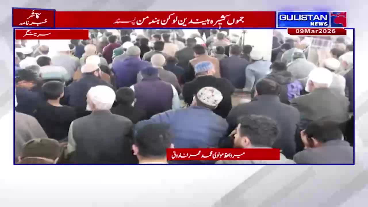A crowd of men, many wearing skullcaps, are gathered in what appears to be an indoor space. A news ticker from Gulistan News scrolls across the bottom of the screen.