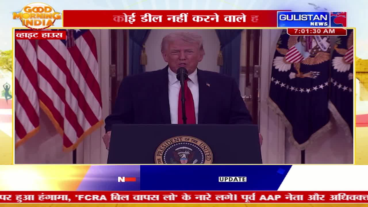 Donald Trump stands at a podium, speaking into a microphone. Two American flags flank him on either side.