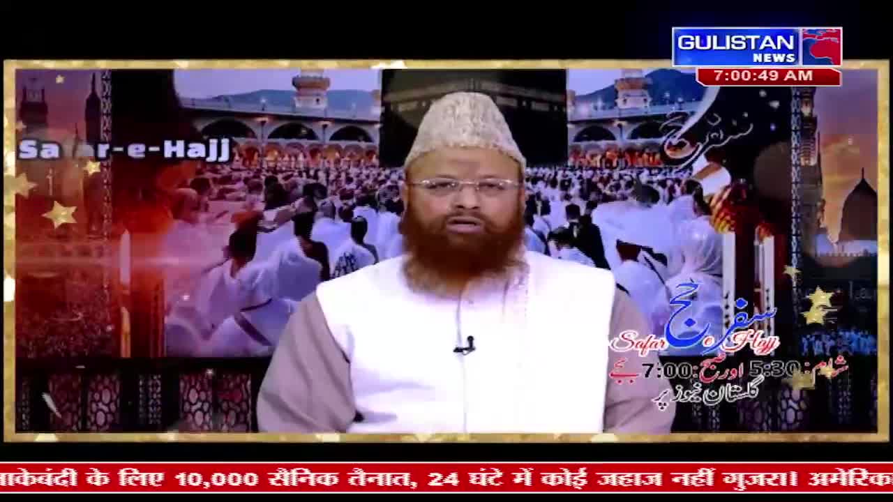 A man in a white cap and vest speaks on Gulistan News. Behind him, a screen shows a vast crowd in white robes around the Kaaba in Mecca.