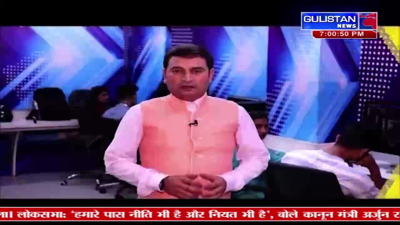 A man in a peach vest over a white shirt speaks directly to the camera. Behind him, other people are visible in a studio setting, with a Gulistan News graphic displayed.