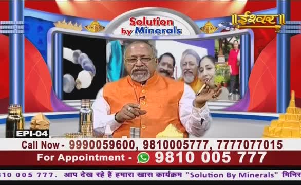On the Ishwar Bhakti TV set, a man in an orange vest gestures with his hand while speaking. Behind him, a screen displays images, and the show's phone numbers are listed at the bottom.
