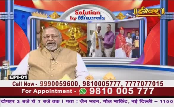 A man in a beige vest sits in front of a screen, speaking on what appears to be Ishwar Bhakti TV. Behind him, a smaller screen shows a group of people, including someone receiving an award.
