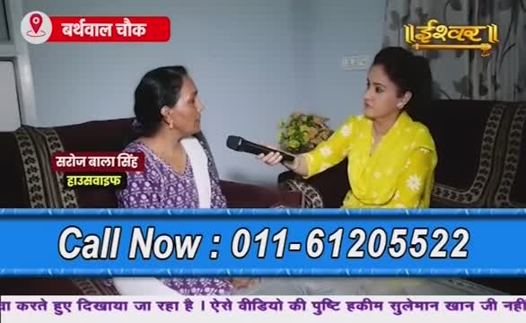 On Ishwar Bhakti TV, a woman in a yellow top holds a microphone, interviewing Saroj Bala Singh, a housewife from Barthwal Chowk. A phone number flashes on the screen, inviting viewers to call.
