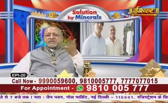 A man in a vest and glasses gestures emphatically while speaking on Ishwar Bhakti TV. Behind him, a screen shows two men, and below, contact information scrolls across the bottom of the frame.
