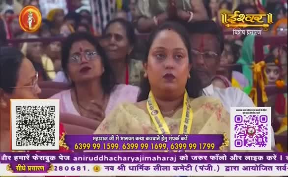 People are seated, watching something off-screen, with expressions of concentration. The scene is being broadcast on Ishwar Bhakti TV, as indicated by the logo and text at the bottom of the screen.

