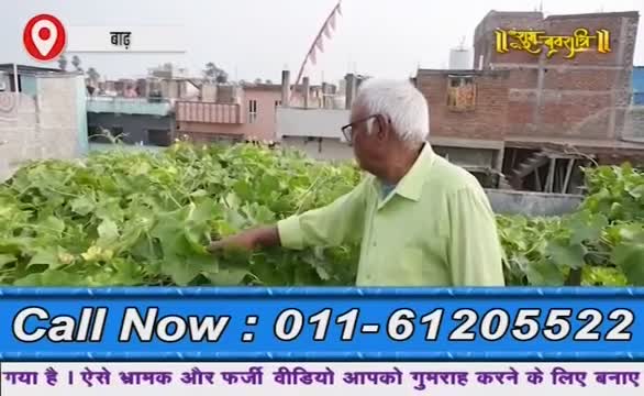 An older man in glasses gestures toward a lush rooftop garden, likely in India, as the camera focuses on him. Below, a phone number flashes on the screen, part of what looks like a segment on Ishwar Bhakti TV.
