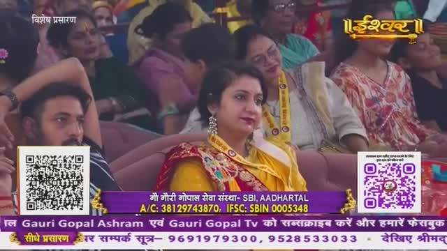 People are seated, watching an event, perhaps a religious broadcast from India, as indicated by the "Ishwar" logo and the text about Gauri Gopal Ashram. A woman in a yellow shawl and ornate earrings looks towards the camera, while a man in the foreground gazes off to the side.
People are seated, watching an event, perhaps a religious broadcast from India, as indicated by the "Ishwar" logo and the text about Gauri Gopal Ashram. A woman in a yellow shawl and ornate earrings looks towards the camera, while a man in the foreground gazes off to the side.