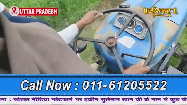 A man's hands grip the steering wheel of a blue tractor, likely in Uttar Pradesh, as seen on Ishwar Bhakti TV. The phone number flashes at the bottom of the screen.
A man's hands grip the steering wheel of a blue tractor, likely in Uttar Pradesh, as seen on Ishwar Bhakti TV. The phone number flashes at the bottom of the screen.