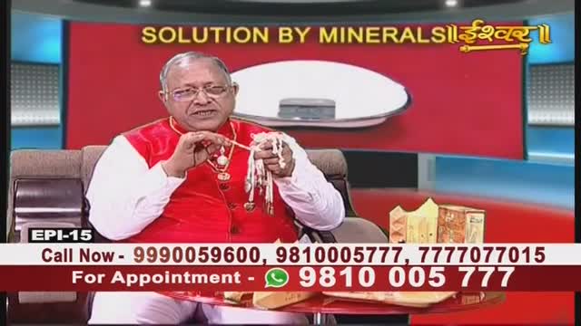 A man in a red vest and glasses holds a string of beads, gesturing with them as he speaks. The Ishwar Bhakti TV program includes phone numbers for appointments and solutions.
