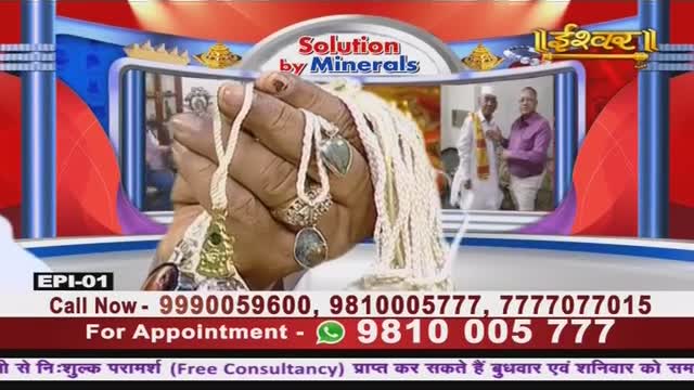 On Ishwar Bhakti TV, a hand displays several necklaces, the pendants catching the light.  Behind, a framed image shows two men in what looks like a temple, while contact information scrolls across the bottom of the screen.
