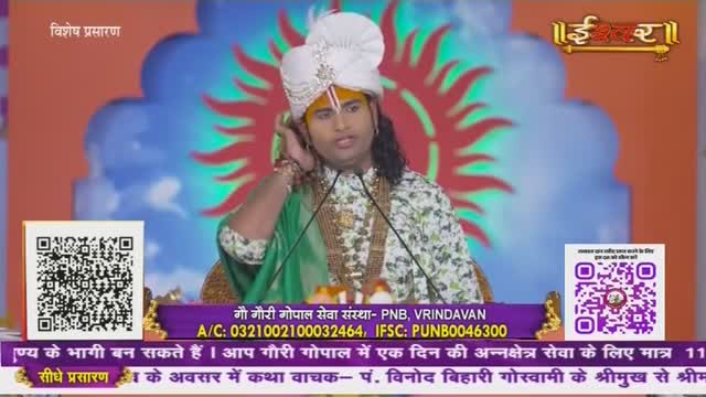 A man in a turban and floral shirt speaks into two microphones, his hand raised to his ear. The broadcast from Ishwar Bhakti TV in India is framed by a colorful backdrop and QR codes.
