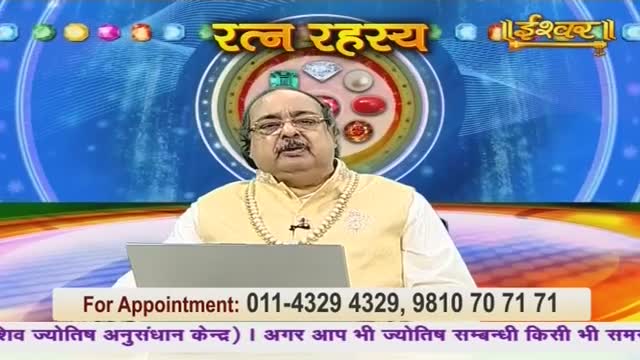 A man in a yellow vest and glasses sits at a desk, facing the camera on Ishwar Bhakti TV in India. Behind him, a graphic displays gems and the words "Ratan Rahasya."
A man in a yellow vest and glasses sits at a desk, facing the camera on Ishwar Bhakti TV in India. Behind him, a graphic displays gems and the words "Ratan Rahasya."