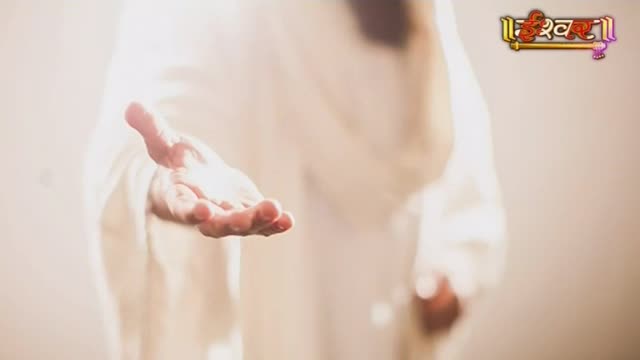A hand, draped in white fabric, extends forward, palm open. The Ishwar Bhakti TV logo hovers in the upper right corner.