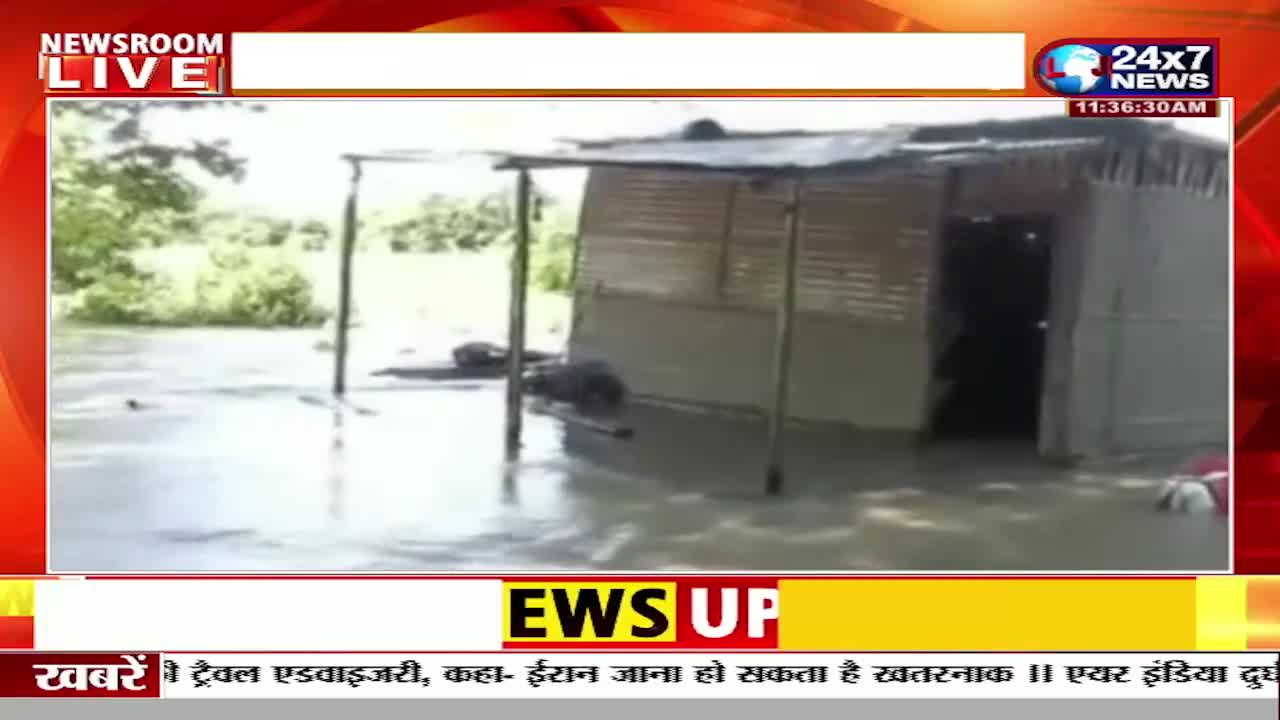 Water surrounds a small, simple structure, the corrugated roof barely above the flood. The JK 24x7 News broadcast is reporting on the situation in India, with the time displayed in the top right corner.
