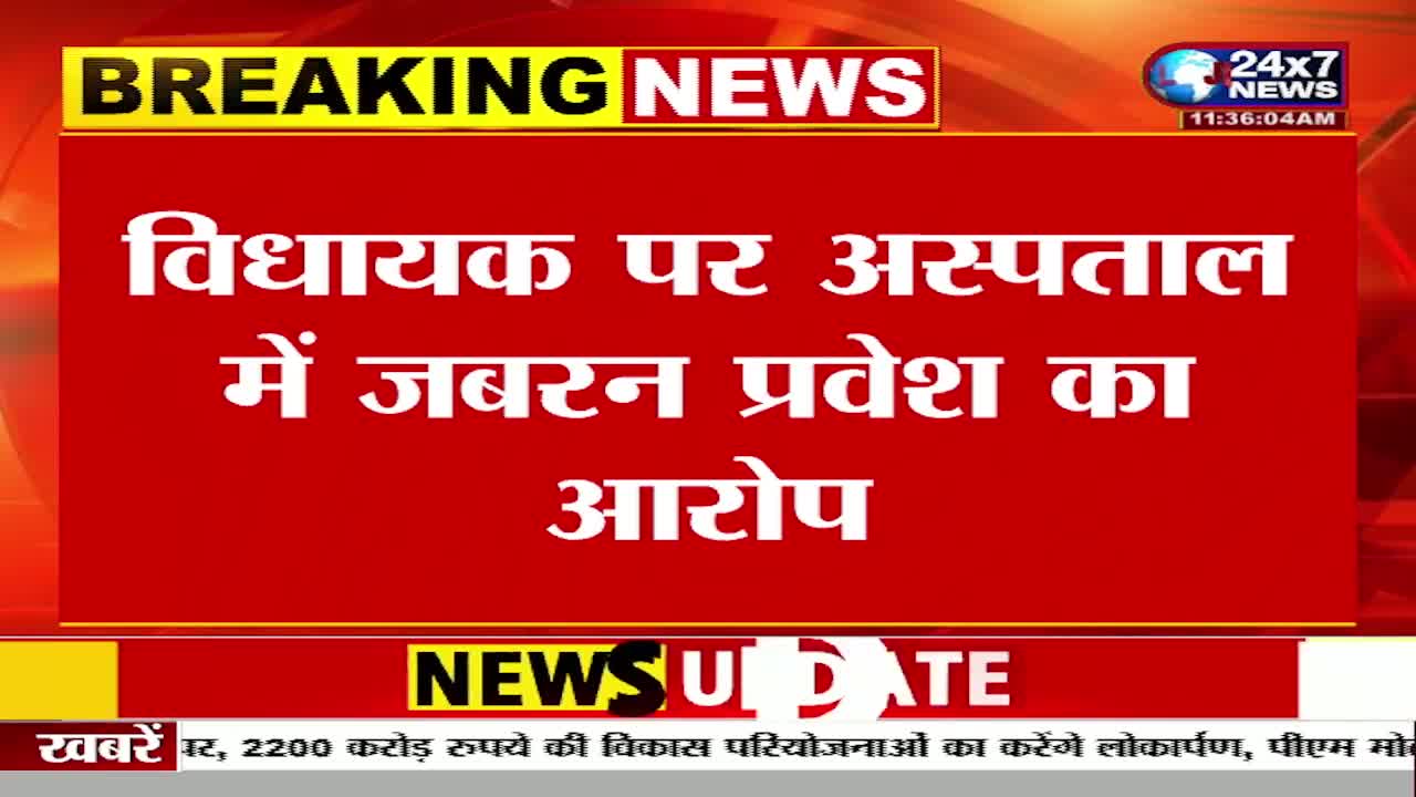 The JK 24x7 News graphic displays a "Breaking News" headline in Hindi about an accusation of forced entry to a hospital involving a "Vidhayak." Below, a "News Update" banner runs across the screen, with text about a development project.
