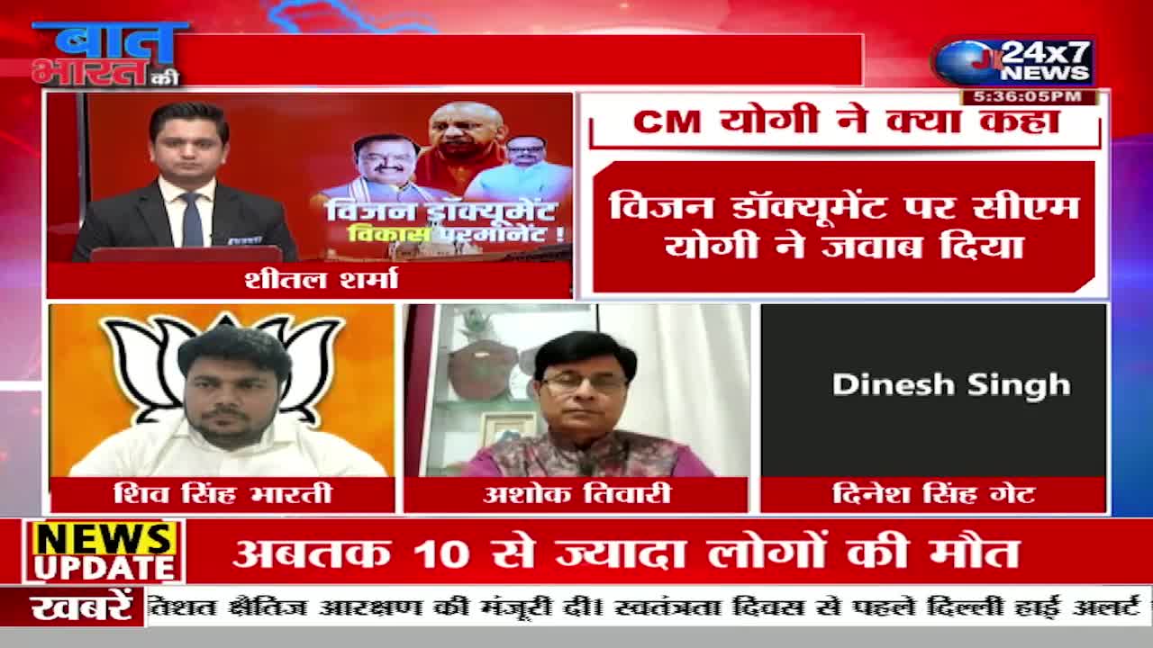 A news broadcast from JK 24x7 News is underway, with a panel of four men discussing a topic related to CM Yogi and a "Vision Document." The bottom of the screen displays a news update about more than 10 deaths.
