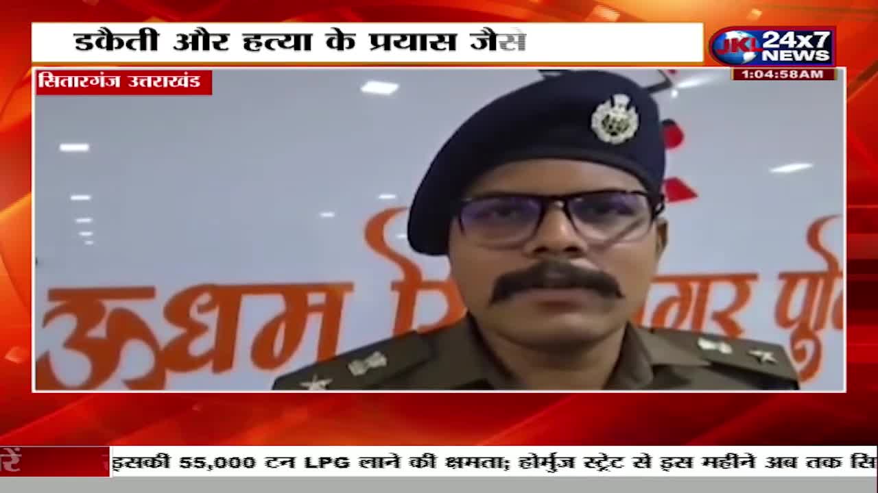 A police officer in uniform stands before a wall with Hindi text. He wears a dark beret and glasses, his mustache prominent. The JK 24x7 News chyron indicates this is a report from Sitarganj, Uttarakhand.