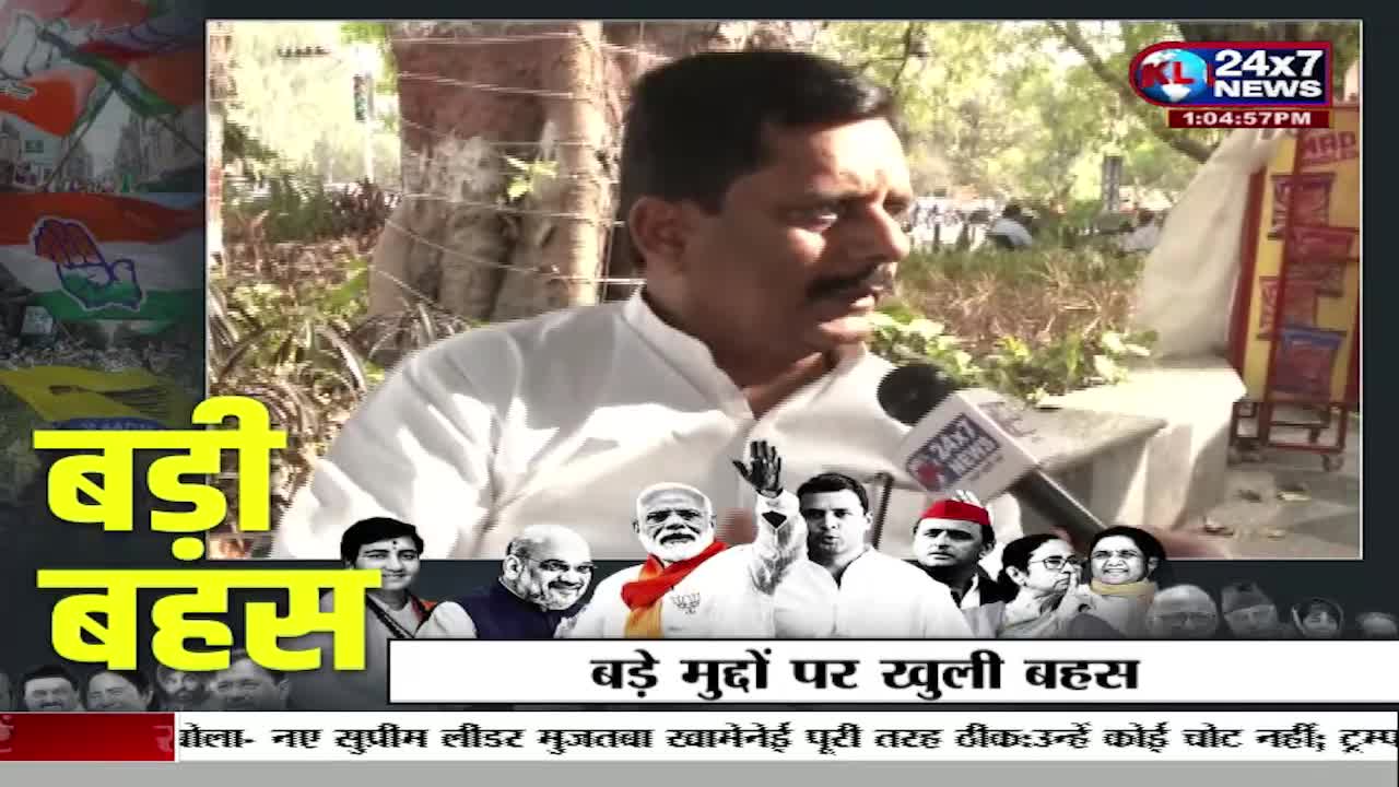 A man in a white kurta speaks into a microphone, while a collage of Indian political figures appears below him. The 24x7 News logo is visible in the upper right corner, and Hindi text overlays the scene.