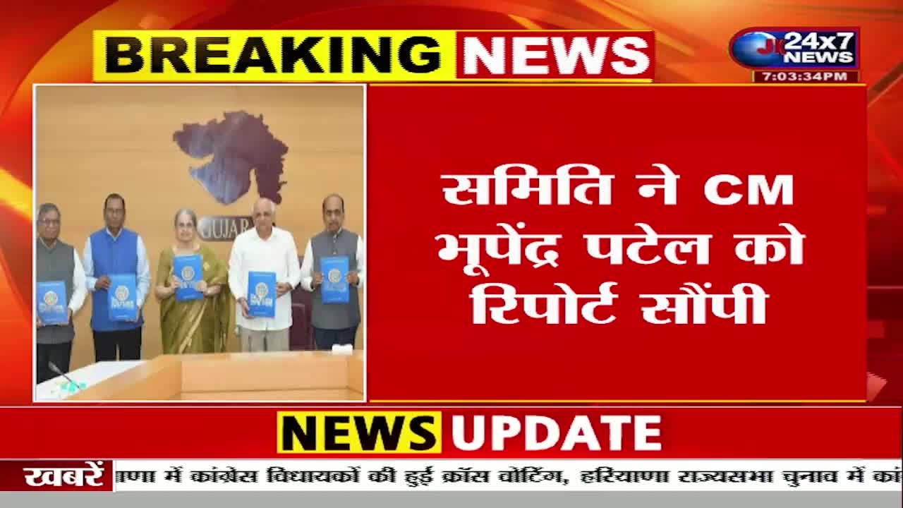 A group of five people stand formally, each holding a blue folder. Behind them, a map of Gujarat is displayed on a wall, and the words "BREAKING NEWS" flash at the top of the screen.