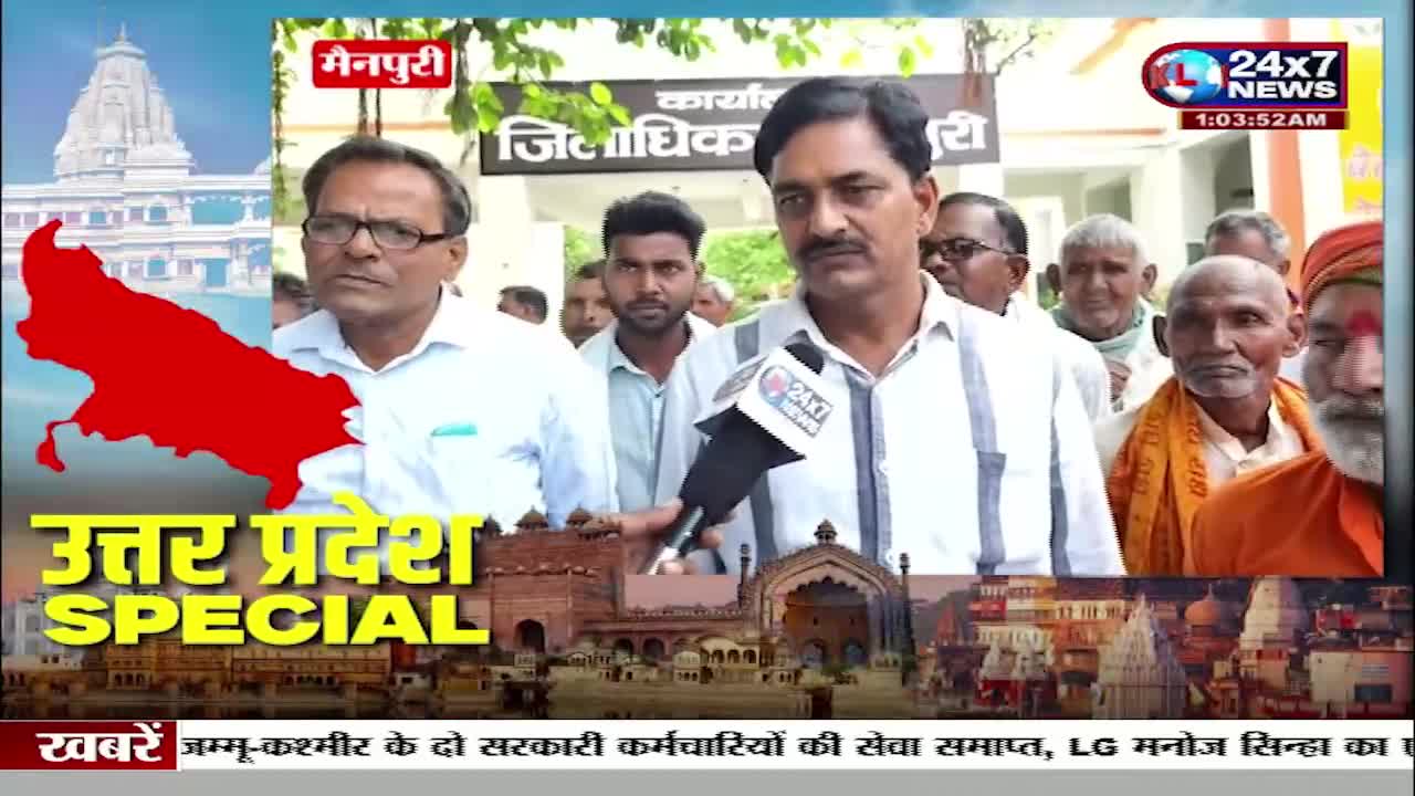 A man with a mustache speaks into a 24x7 News microphone while a crowd of people, some with weathered faces, stand behind him. The backdrop features a red outline of Uttar Pradesh and text in Hindi. A man with a mustache speaks into a 24x7 News microphone while a crowd of people, some with weathered faces, stand behind him. The backdrop features a red outline of Uttar Pradesh and text in Hindi.