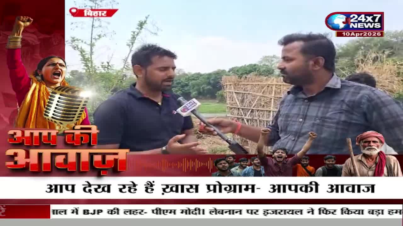 A reporter holds a microphone towards a man speaking animatedly. Behind them, a group of young men are raising their fists in the air. A reporter holds a microphone towards a man speaking animatedly. Behind them, a group of young men are raising their fists in the air.