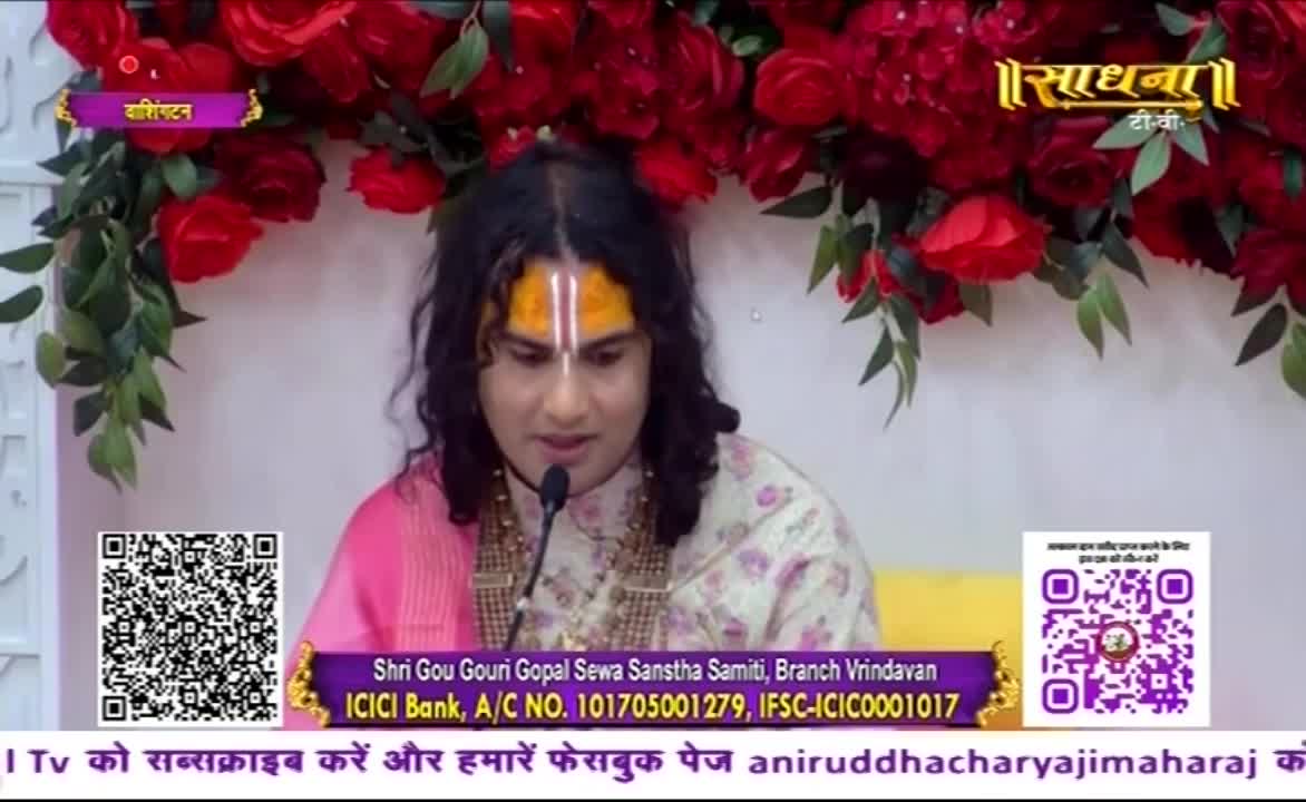 A man with a painted forehead and long hair speaks into a microphone, framed by a floral backdrop. The Sadhna TV logo is visible, and there are QR codes on the screen.
