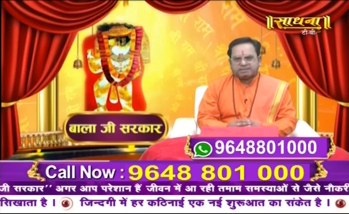 A man in saffron robes sits before a backdrop featuring a deity, likely part of a broadcast on Sadhna TV. A phone number is prominently displayed, inviting viewers to call for guidance.
