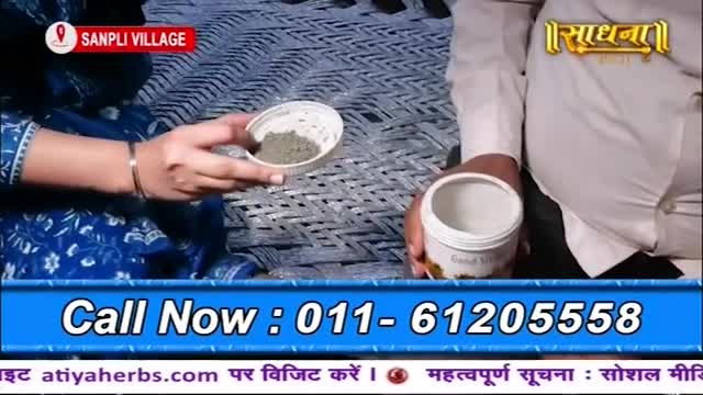 A woman holds a small bowl of grey powder, while a man next to her cradles a white jar. The Sadhna logo and a phone number are prominently displayed below.

