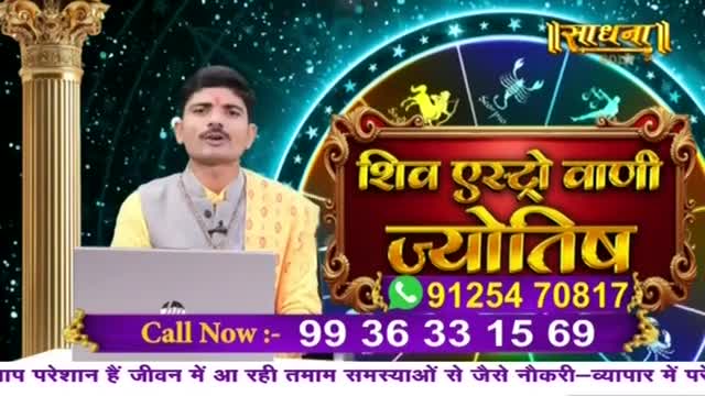 A man in a yellow shirt and gray vest is speaking in front of a laptop, with a Sadhna logo and Hindi text behind him. The screen displays a phone number and a call-to-action, offering astrological advice.
