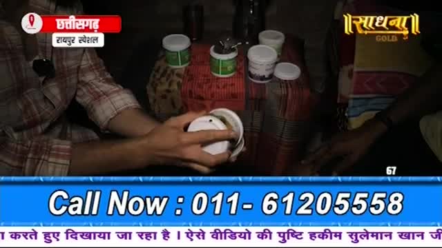 A man in a plaid shirt is opening a small white container. Several other similar containers sit on a patterned cloth.