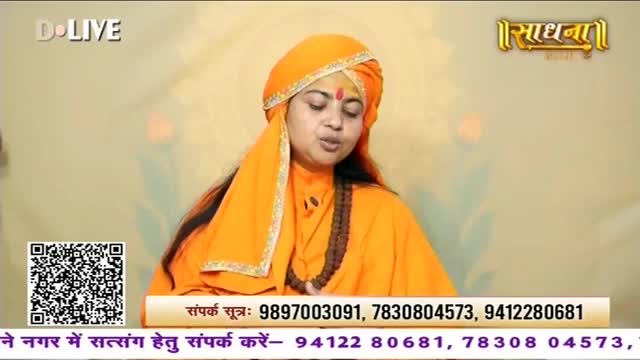 A woman in an orange sari and turban speaks, her face illuminated. A QR code and contact numbers are displayed below her.