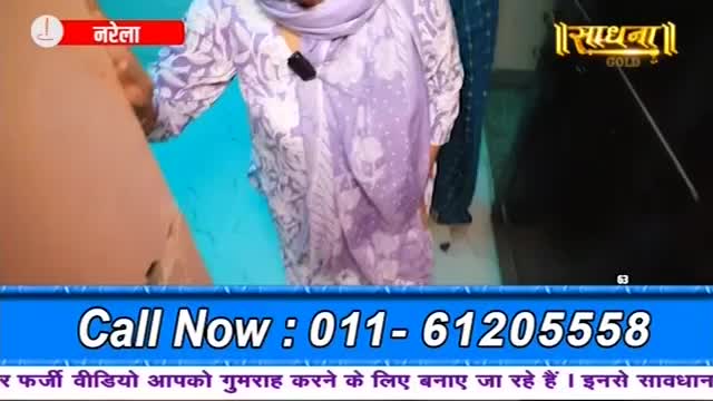 A woman in a patterned kurta walks past a bright blue wall. A logo for "Sadhna Gold" is visible on a dark surface.