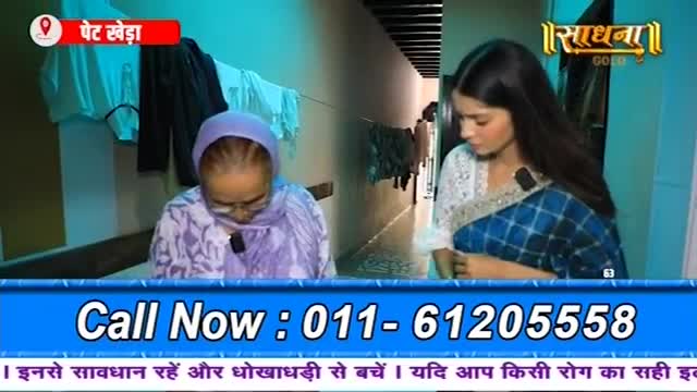 An older woman, wearing a purple headscarf, looks down at something in her lap. Beside her, a younger woman in a blue and white sari gazes downwards, her expression thoughtful.