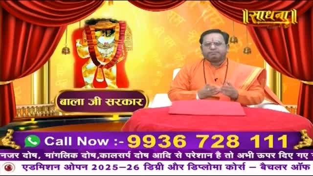 A man in an orange robe sits at a table, his hands clasped. Behind him, a colorful image of a deity is displayed. Text at the bottom of the screen offers a phone number and information about courses.