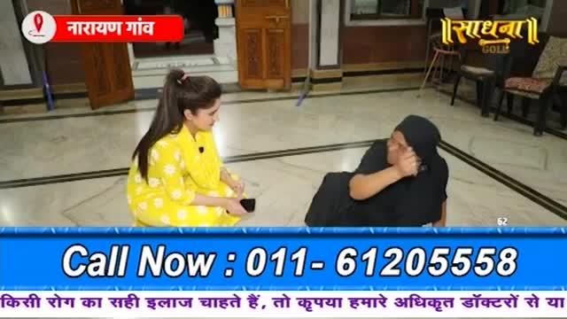 A woman in a yellow dress sits on the floor, looking at another woman in black who is lying down and talking on a phone. The "Sadhna Gold" logo is visible in the background.