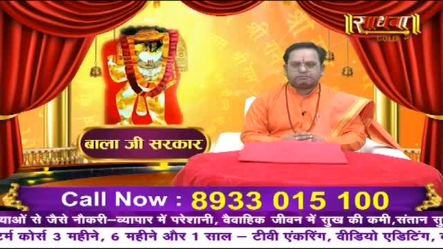 A man in an orange robe sits behind a red cushion, his hands clasped. Behind him, a vibrant image of a deity is displayed, framed by rich red curtains. A man in an orange robe sits behind a red cushion, his hands clasped. Behind him, a vibrant image of a deity is displayed, framed by rich red curtains.