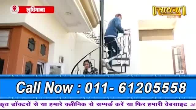 A man in a blue jacket climbs a spiral staircase. Below him, a person in a checkered shirt watches from a lower landing.