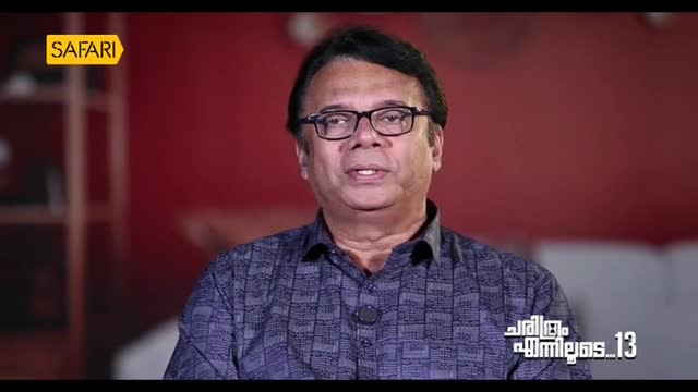 The man in the glasses is speaking, his expression earnest as he looks directly at the camera. A "Safari" logo is in the corner, and Malayalam text is visible on the screen.
