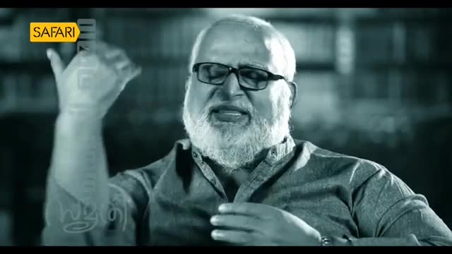 A man with a white beard and glasses gestures with his right hand, speaking animatedly. The Safari TV logo is visible in the upper left corner.
