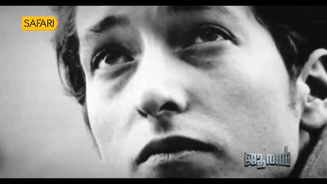 A close-up of a man's face fills the screen, his gaze directed upwards. The Safari TV logo sits in the corner, and Malayalam text is visible at the bottom.
