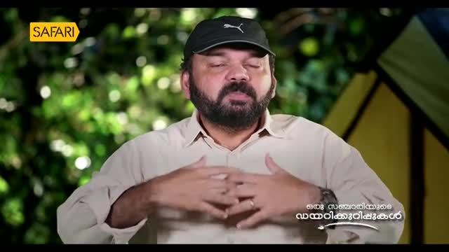 The man, wearing a cap and light shirt, has his eyes closed and hands clasped over his chest. The Safari TV logo is visible in the top left corner.
