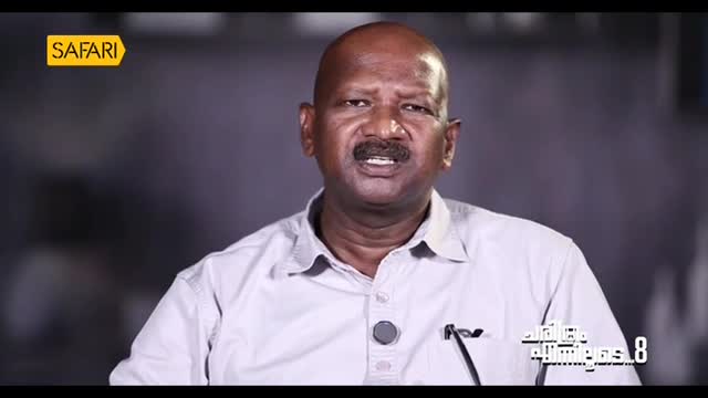 The man in the light-colored shirt is speaking, his mouth open as if mid-sentence. A logo from Safari TV is visible in the upper left corner.
