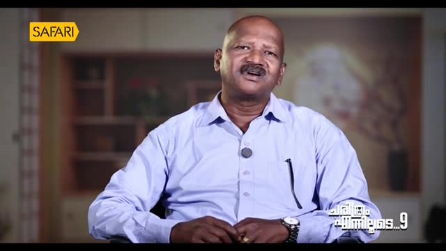 A man in a light blue shirt speaks, his hands resting on the arms of his chair. The Safari TV logo is visible in the top left corner.
