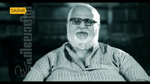 A man with a white beard and glasses is speaking, his mouth slightly open. The Safari TV logo is visible in the top left corner.
