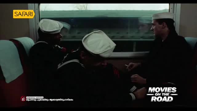 Three men in sailor uniforms are seated on a train, a cigarette held between the fingers of one. The "Safari" logo suggests this scene is from a movie being broadcast on Indian television.
