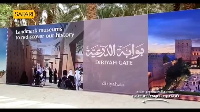 A large banner, likely for a Safari TV segment, displays images of Diriyah Gate and its museums. People mill about in front of the banner, which is written in both English and Arabic.
A large banner, likely for a Safari TV segment, displays images of Diriyah Gate and its museums. People mill about in front of the banner, which is written in both English and Arabic.