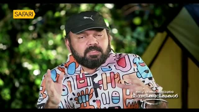 The man, wearing a Puma cap and a colorful shirt, gestures with his hands as he speaks. The Safari TV logo is visible in the corner.
The man, wearing a Puma cap and a colorful shirt, gestures with his hands as he speaks. The Safari TV logo is visible in the corner.